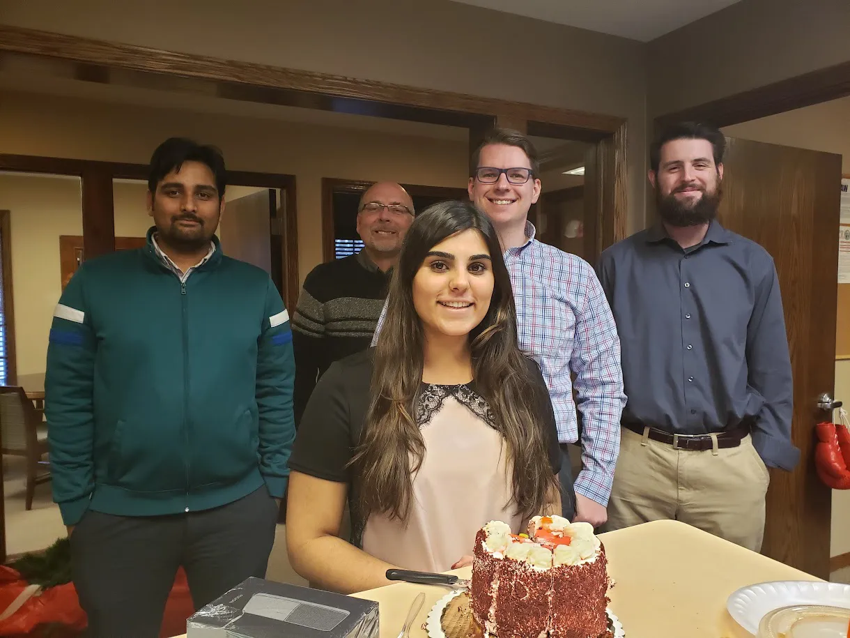 a photo of the jms team in 2018 with intern priya on her birthday